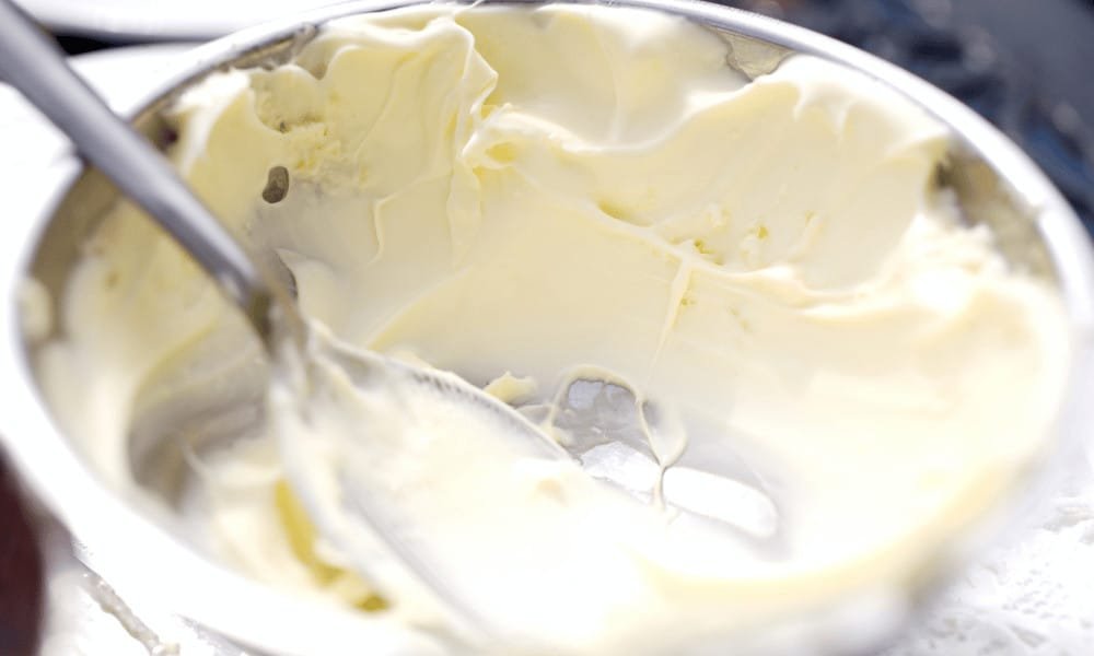 A silver bowl full of creamy clotted cream