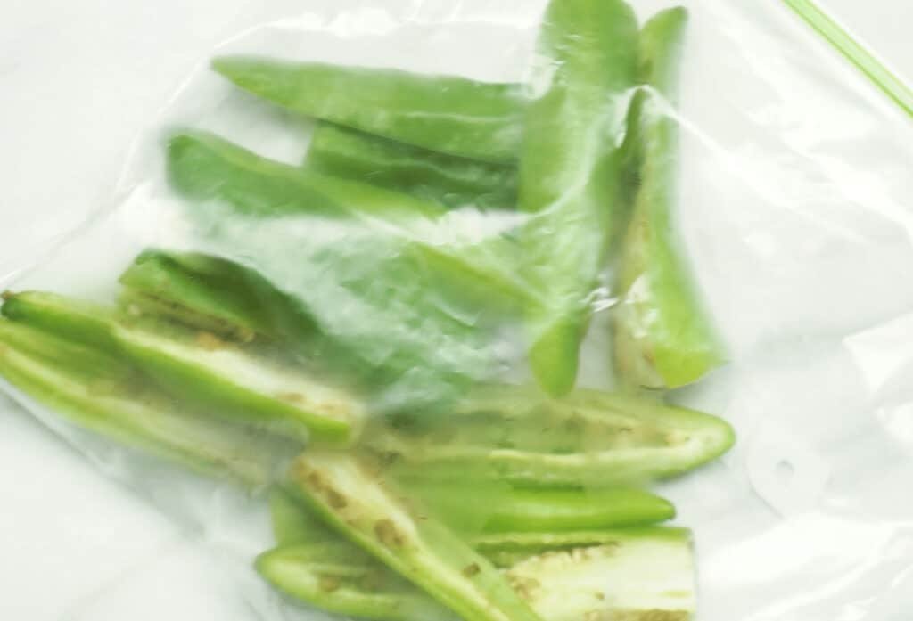 Green chilli halves sealed in a freezer bag for freezing