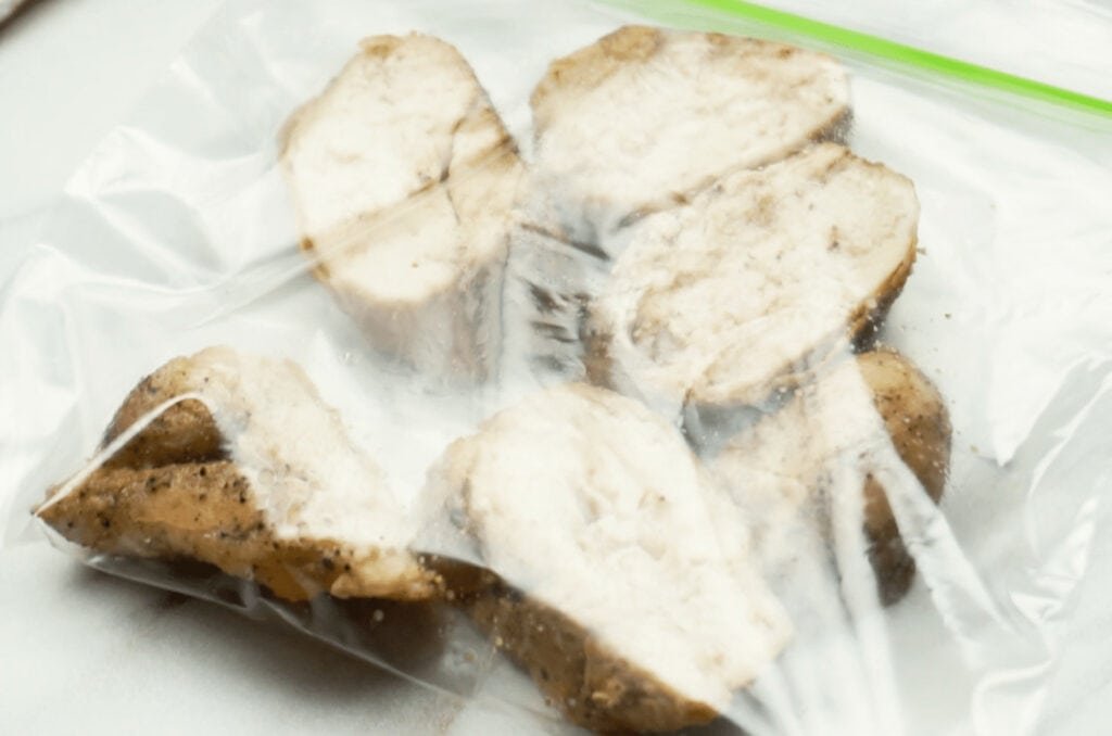 Sliced chicken breast in a seal plastic bag ready for freezing