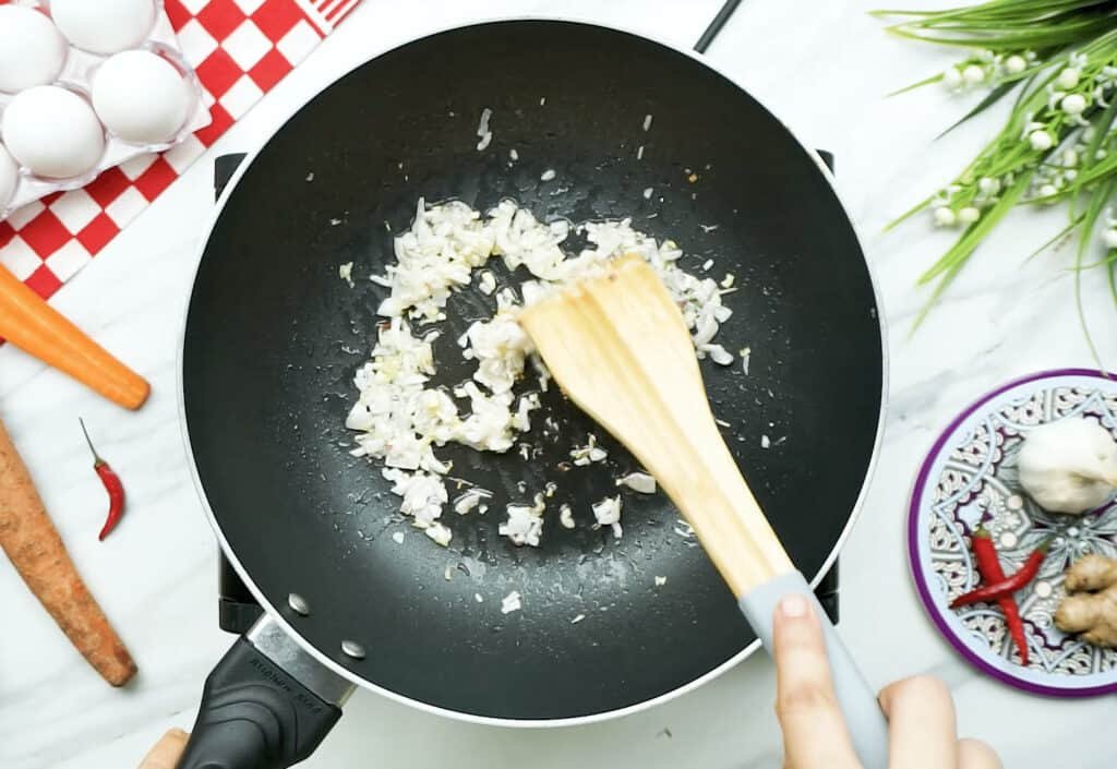 Diced onions cooking in a large frying pan