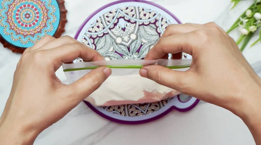 A woman's hands sealing a freezer bag filled with double cream